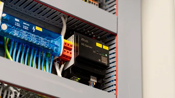 Electrical control panel open with wiring and components inside the metal cover