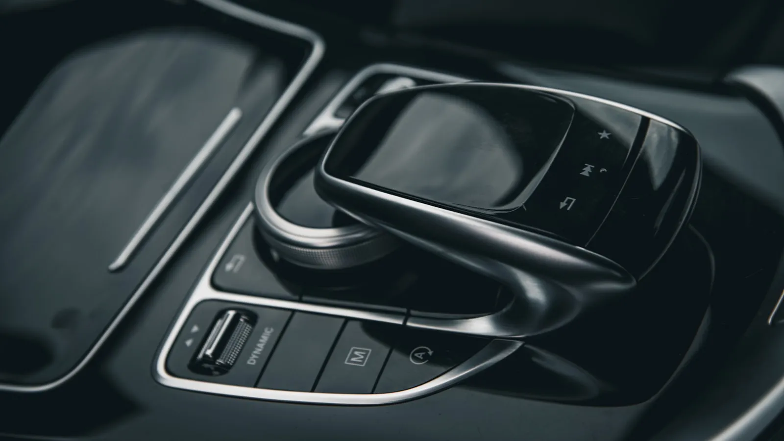 Premium car interior with rotary dial and drive-mode controls, dark and moody
