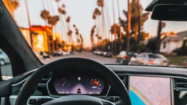 Interior view of a Tesla showing the dashboard, steering wheel, and touchscreen
