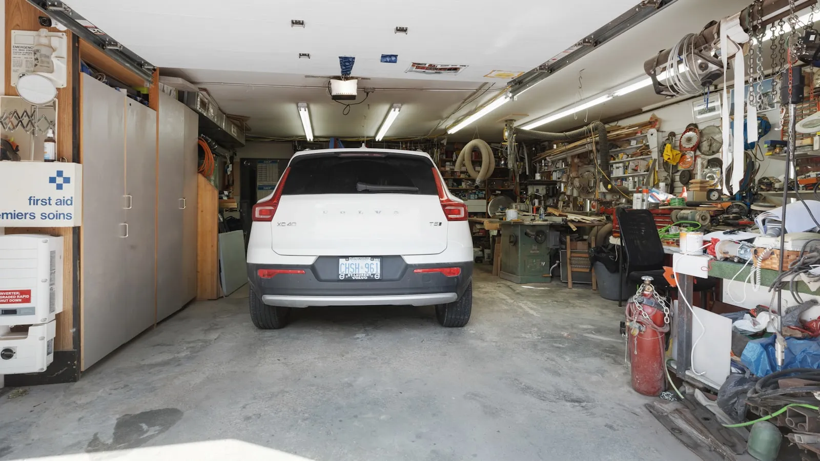 Interior of a residential garage with a white car parked inside
