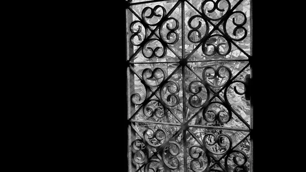 Ornate wrought iron gate against a dark background