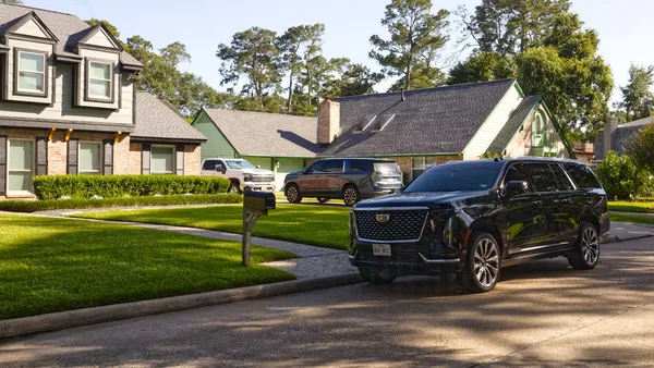 Black full-size SUV parked in a suburban residential driveway
